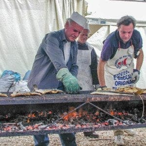 klippfisk blir grillet av tre mennesker