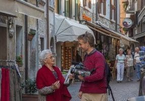 Eldre dame og ung mann skanner sammen i gata